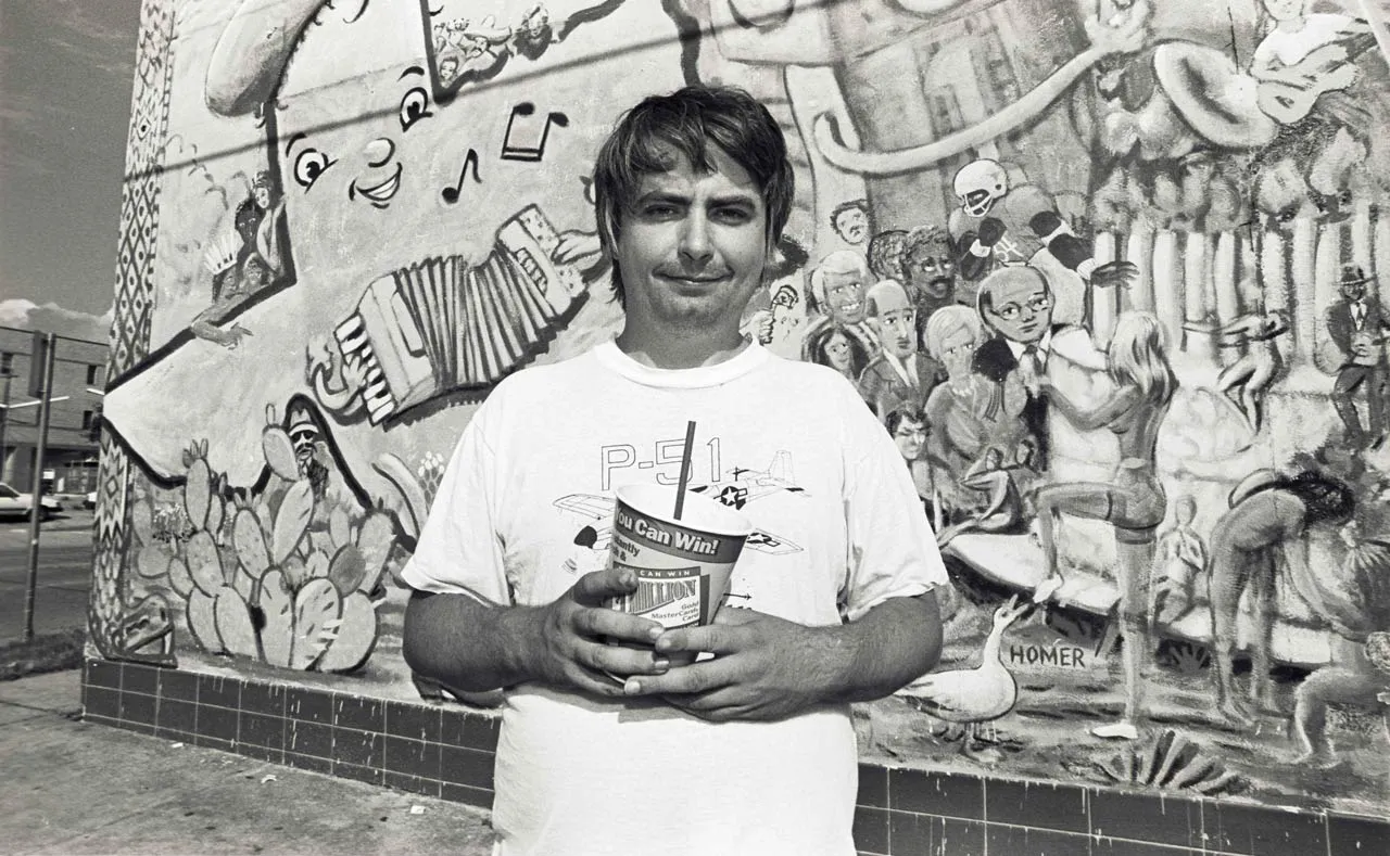 Daniel Johnston in front of a graffiti wall